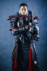 Portrait of a medieval female knight in armour over blue background.