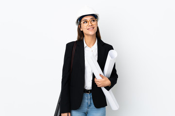 Young architect caucasian woman with helmet and holding blueprints over isolated background...