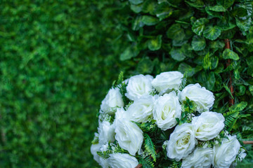 Obraz na płótnie Canvas Bouquet of white roses on a green background. Decor for wedding