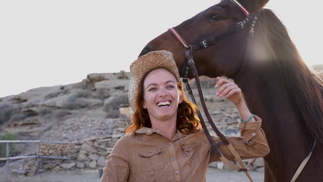 Young farmer woman playing with her horse in a sunny day inside corral ranch - Concept about love between people and animals - Slow Motion