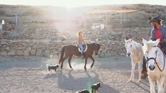 Young people riding horses inside corral - Wild couple having fun in equestrian ranch  - Training, culture, passion, excursion, healthy lifestyle, sport concept - Slow Motion