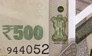 close up image of Indian currency 500 rupee note displaying State Emblem of India