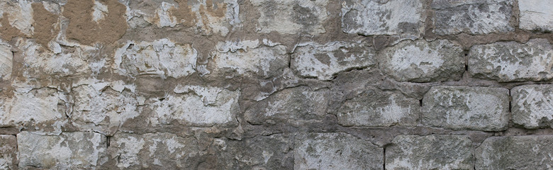 Background from an old weathered grungy broken stone wall covered with cement from abandoned house.