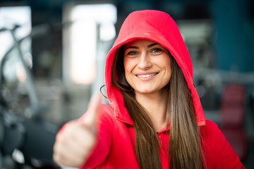 Fit woman in red hoodie in gym