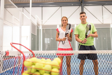 Couple playing paddle tennis in blue court