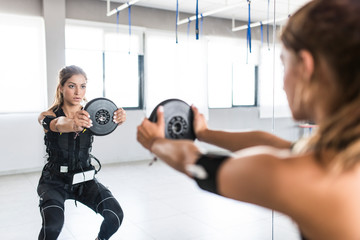 Woman training with electro stimulator