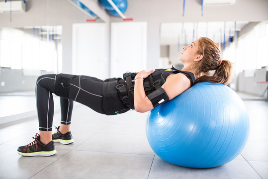 Woman training with electro stimulator