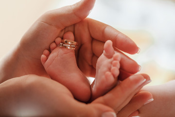 Baby feet in mother hands. Mom and her Child. Happy Family concept. Beautiful conceptual image of Maternity
