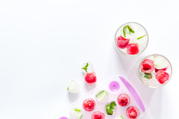 Raspberry and lime in ice cubes on white table top view copy space