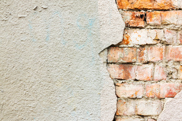 Textured background of an old brick wall, plaster fell off, the building wall was destroyed outside