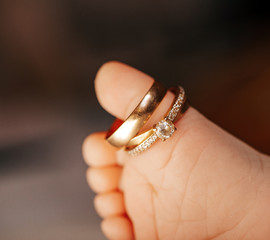 Legs of a newborn baby with mom's wedding ring. Family concept. 