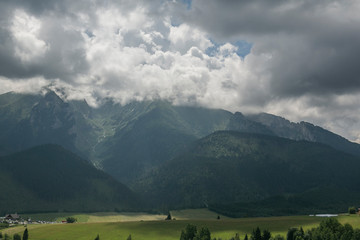 Fototapeta na wymiar Mountain range in clouds backlit by sunlight