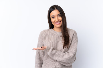 Young brunette woman over isolated white background presenting an idea while looking smiling towards