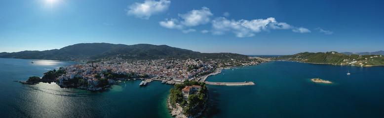 Naklejka na ściany i meble Aerial drone panoramic photo of picturesque main town of Skiathos island featuring small landmark peninsula of Bourtzi, Sporades, Greece