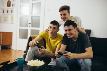 teenager boy playing games on console at home