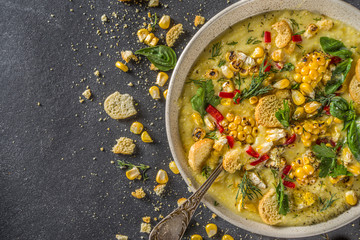 Homemade autumn classic corn cream soup with grilled corn, herbs and croutons, copy space