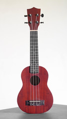 Ukulele guitar made of wood on white background. 4 strings of voice used to deck playing music to relax.