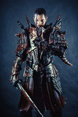 Fototapeta premium Powerful knight in the armor with the sword. Dark background.