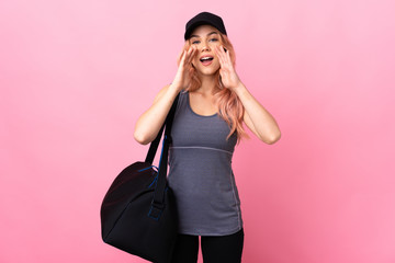 Teenager sport woman with sport bag over isolated background shouting and announcing something