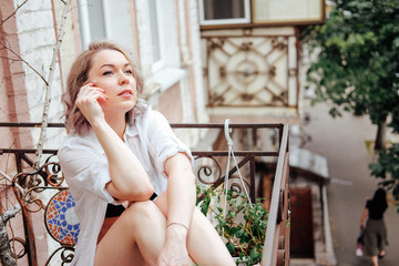 French balcony leisure time. Woman relaxing at home.