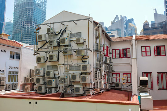 An Apartment With Full Of Air Conditioners Hang On The Wall In Singapore.