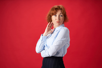 Beautiful redhead woman surprised on red background