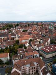 Fototapeta na wymiar Aerial view of Nuremberg old town on Pegnitz river. Ancient buildings architecture half-timbered houses with red roofs. Cityscape rooftops. Trees. Germany. Europe.