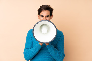 Man over isolated background shouting through a megaphone