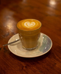 Glass of Coffee Piccolo Latte on a wooden table