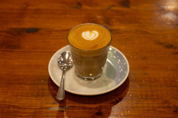 Glass of Coffee Piccolo Latte on a wooden table