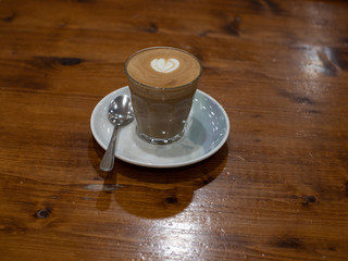 Glass of Coffee Piccolo Latte on a wooden table