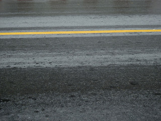 wet asphalt road with yellow line of lane after rain