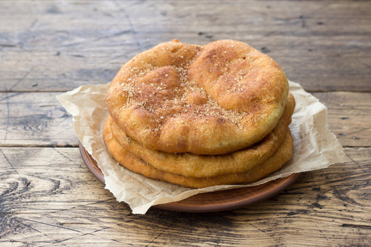 Homemade Navajo fried bread or sweet Elephant Ears with brown sugar and cinnamon  on wooden table