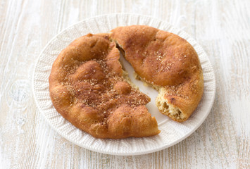 Homemade Navajo fried bread or sweet Elephant Ears with brown sugar and cinnamon  on wooden table