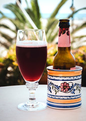 A cherry beer in glass and bottle