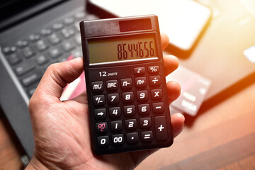 Obraz premium hand holding calculator in office, business concept