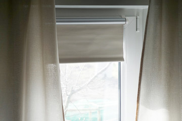 window with textile curtains and blackout roller blinds