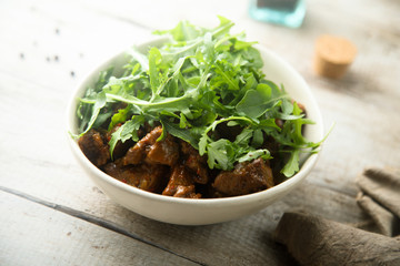 Homemade beef ragout with fresh arugula