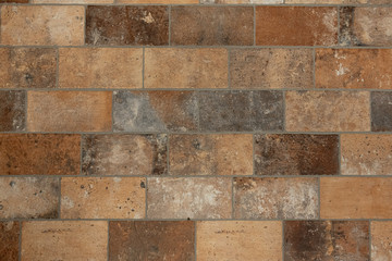 Earth-colored brown beige floor tiles in brick pattern form give a warm surface.