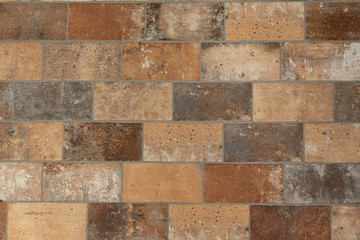 Earth-colored brown beige floor tiles in brick pattern form give a warm surface.