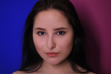 emotional portrait of a brunette girl on a pink-blue background
