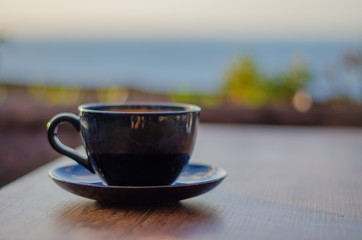 coffee cup on wooden table, black color
