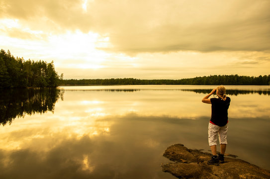 Woman using binoculars while a hiking in the lake