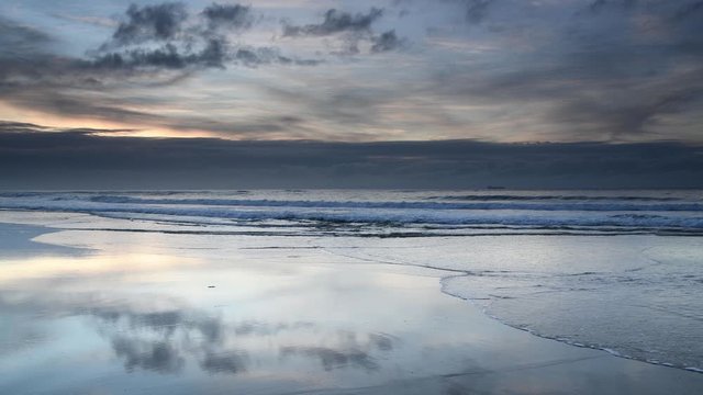 Soft Blue Sunrise Seascape with Reflections on the Beach and Clouds