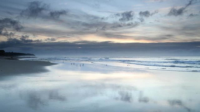 Soft Blue Sunrise Seascape with Reflections on the Beach and Clouds