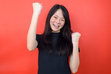 Portrait of Young beautiful asian woman using black T-shirt with red isolated background