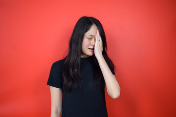 Portrait of Young beautiful asian woman using black T-shirt with red isolated background