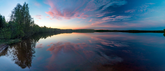 Mirror image of the sunset on the lake in spring.Panorama.