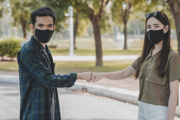 Asian women man a wearing face mask hello shake hand new normal social distancing,No touching