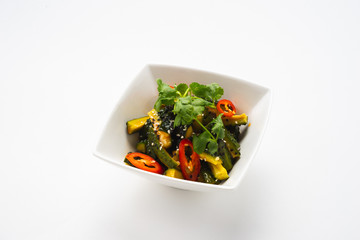 Traditional oriental salad of fresh vegetables in a deep white bowl on a white background, isolate.